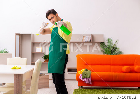 Young male contractor cleaning the house indoors Young male contractor cleaning the house indoors 77108922