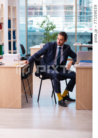 Young male employee working in the office 77109039