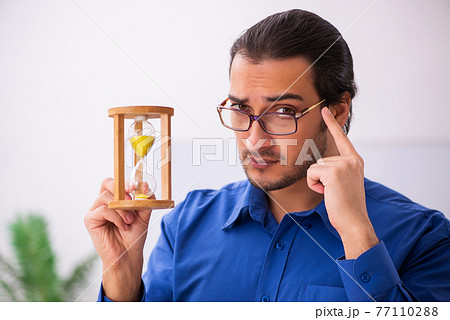Young male teacher in time management concept Young male teacher in time management concept 77110288