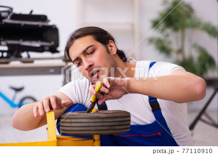 Young male repairman repairing trolley indoors Young male repairman repairing trolley indoors 77110910
