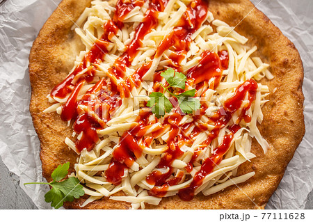 Cheesy hungarian traditional baked langos with 77111628