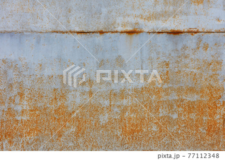 Rust shows through on an old sheet of metal texture painted with gray paint. Rust shows through on an old sheet of metal texture painted with gray paint. 77112348