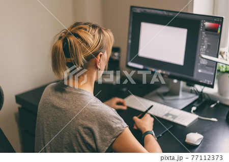 Woman drawing on graphic tablet Woman drawing on graphic tablet 77112373
