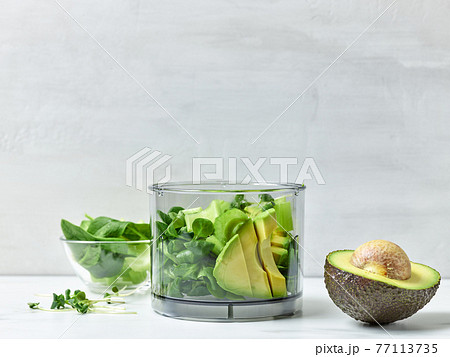 avocado, celery and spinach in plastic transparent blender container 77113735