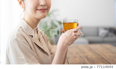家でお茶を飲む若い女性 77114044