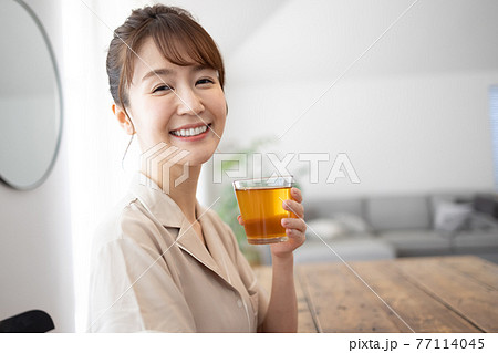 家でお茶を飲む若い女性 家でお茶を飲む若い女性 77114045