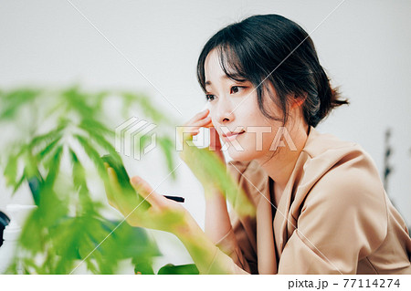 笑顔でメイクをする若い女性 笑顔でメイクをする若い女性 77114274