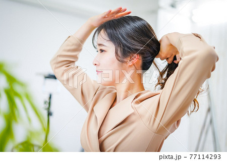 笑顔でメイクをする若い女性 77114293