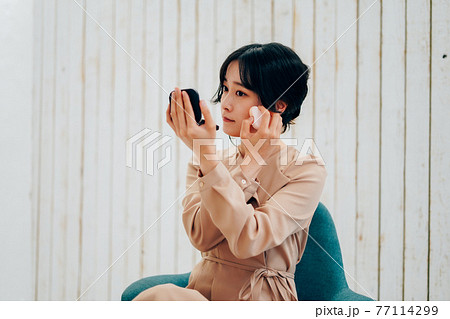 笑顔でメイクをする若い女性 笑顔でメイクをする若い女性 77114299