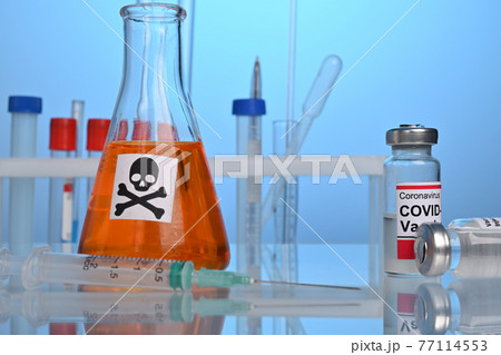 Covid-19 Vaccination Set on a Lab Desk with Death Remedy Covid-19 Vaccination Set on a Lab Desk with Death Remedy 77114553