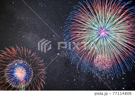 夏イメージ 満天の星空の下 打ち上がる花火 の写真素材