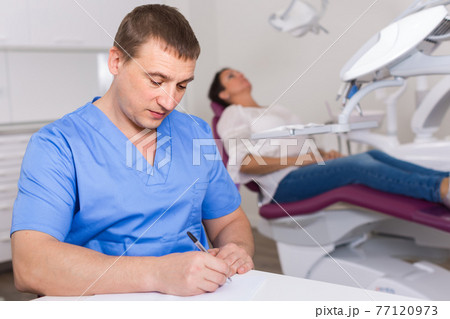 dentist in uniform writing document 77120973