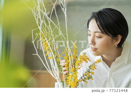 花瓶に花を生ける女性の写真素材