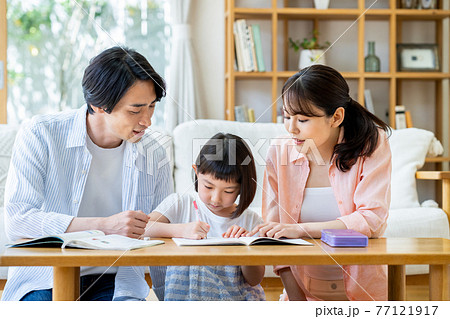 リビングで勉強する小学生の女の子と両親 77121917