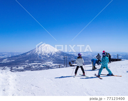 春先の晴れた日のスキー場で羊蹄山を眺めるスキーヤー達 ニセコ 北海道 の写真素材