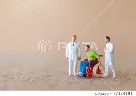 Miniature people , Patient in wheelchair consulting with doctor Miniature people , Patient in wheelchair consulting with doctor 77124191