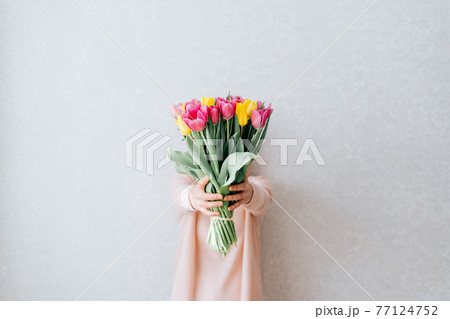 Cropped woman holding tulips. 77124752