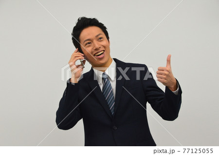 スマホで話す若い男性 スマホで話す若い男性 77125055