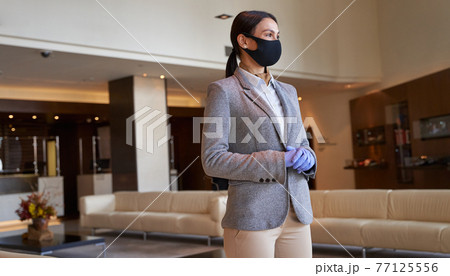 Attractive female hotel employee standing alone at work Attractive female hotel employee standing alone at work 77125556