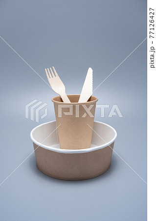 Wooden and cardboard disposable tableware on a gray background. Environmentally friendly products. 77126427