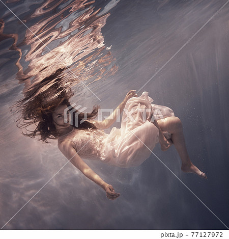 Girl in a white dress underwater 77127972