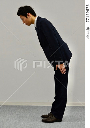 お辞儀をする若い男性 お辞儀をする若い男性 77129678