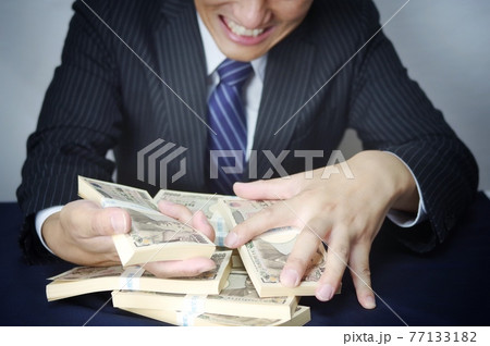 お金とスーツ姿の男性 77133182