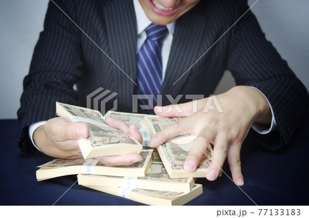 お金とスーツ姿の男性 77133183