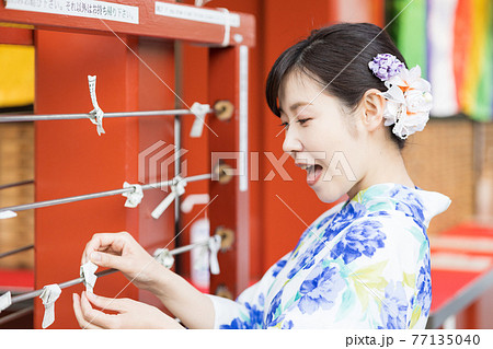 おみくじを結ぶ浴衣の女性 77135040