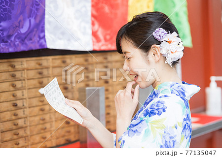 おみくじを引く浴衣の女性 77135047