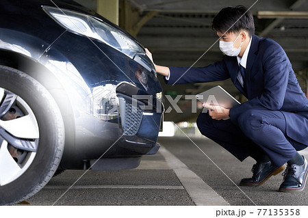 自動車をチェックするマスク姿の男性 77135358