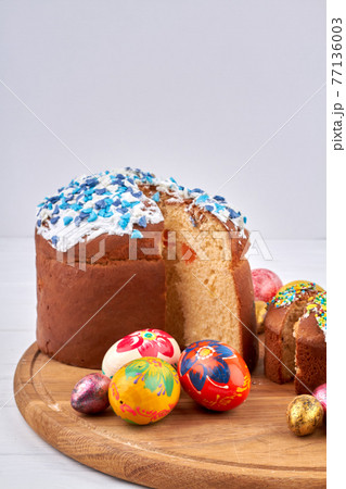 Coloured eggs and homemade easter cakes on white background. 77136003
