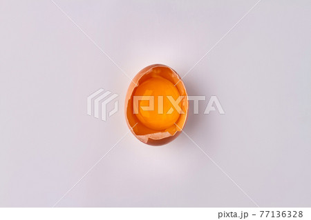 Raw cracked chicken egg with yolk. Raw cracked chicken egg with yolk. 77136328