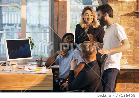 Colleagues working together in modern office using devices and gadgets during creative meeting Colleagues working together in modern office using devices and gadgets during creative meeting 77136459