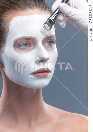 Beautiful girl is applied a white cosmetic mask from black dots. Isolate, studio Beautiful girl is applied a white cosmetic mask from black dots. Isolate, studio 77137817