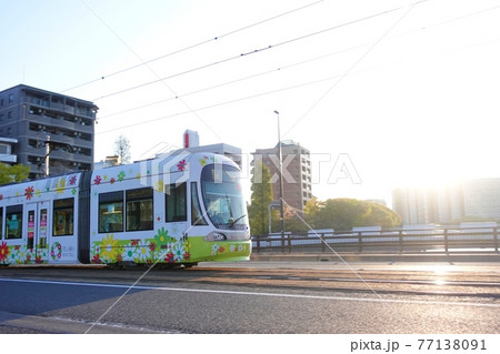 《広島市》朝日を浴びながら走行する路面電車 77138091