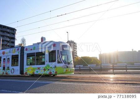 《広島市》朝日を浴びながら走行する路面電車 77138095