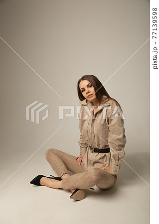 Portrait of young caucasian brunette woman in a beige blouse posing Portrait of young caucasian brunette woman in a beige blouse posing 77139598