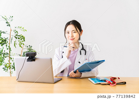 診察する若い女性医師 77139842