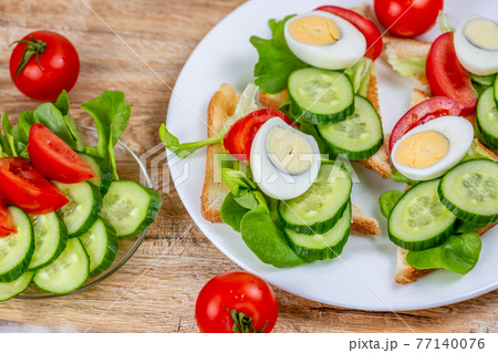 Fried bread toasts with vegetable and egg slices and salad Fried bread toasts with vegetable and egg slices and salad 77140076
