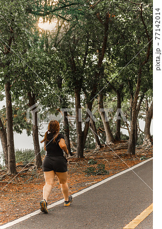Asian oversize woman walking exercise in the park. Asian oversize woman walking exercise in the park. 77142014