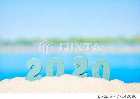 Beautiful blurred view of the beach and with numbers 2020 as a symbol of the year of vacation and travel. Beautiful blurred view of the beach and with numbers 2020 as a symbol of the year of vacation and travel. 77142096