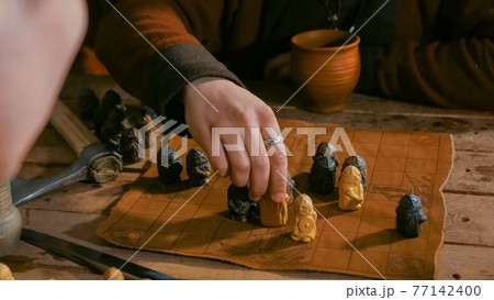 Two men playing popular strategy board game - tafl Two men playing popular strategy board game - tafl 77142400