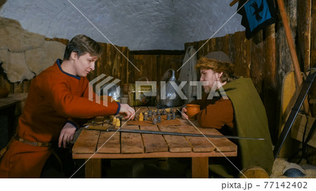 Two men playing popular strategy board game - tafl 77142402