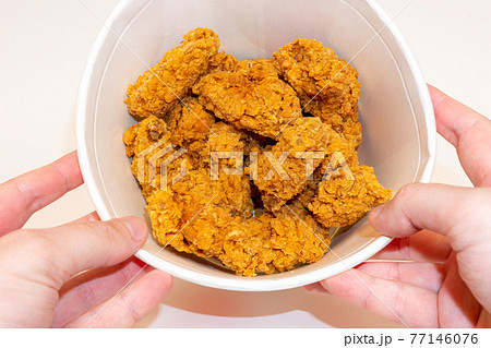 Deep fried spicy chicken wings in a crispy breading in a basket in hands, chicken fast food isolated on white background Deep fried spicy chicken wings in a crispy breading in a basket in hands, chicken fast food isolated on white background 77146076