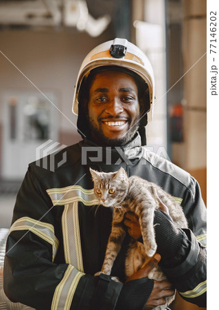Portrait of a firefighter standing in front of a fire engine 77146202