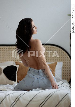 Topless woman touching breast in bedroom Topless woman touching breast in bedroom 77147655