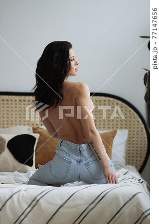 Topless woman touching breast in bedroom Topless woman touching breast in bedroom 77147656
