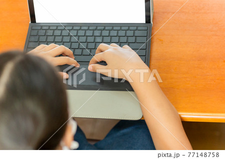 Young student with protective mask hands typing on laptop. Young student with protective mask hands typing on laptop. 77148758