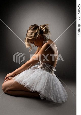 Topless ballerina kneeling on floor during dance 77150525